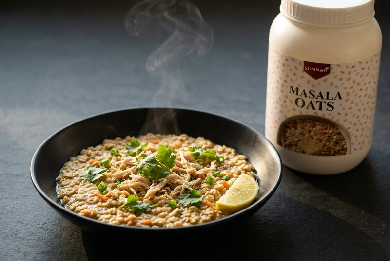 Steaming bowl of chicken masala oats topped with shredded chicken, coriander and a lemon wedge, beside a Sunnah Grains Masala Oats jar